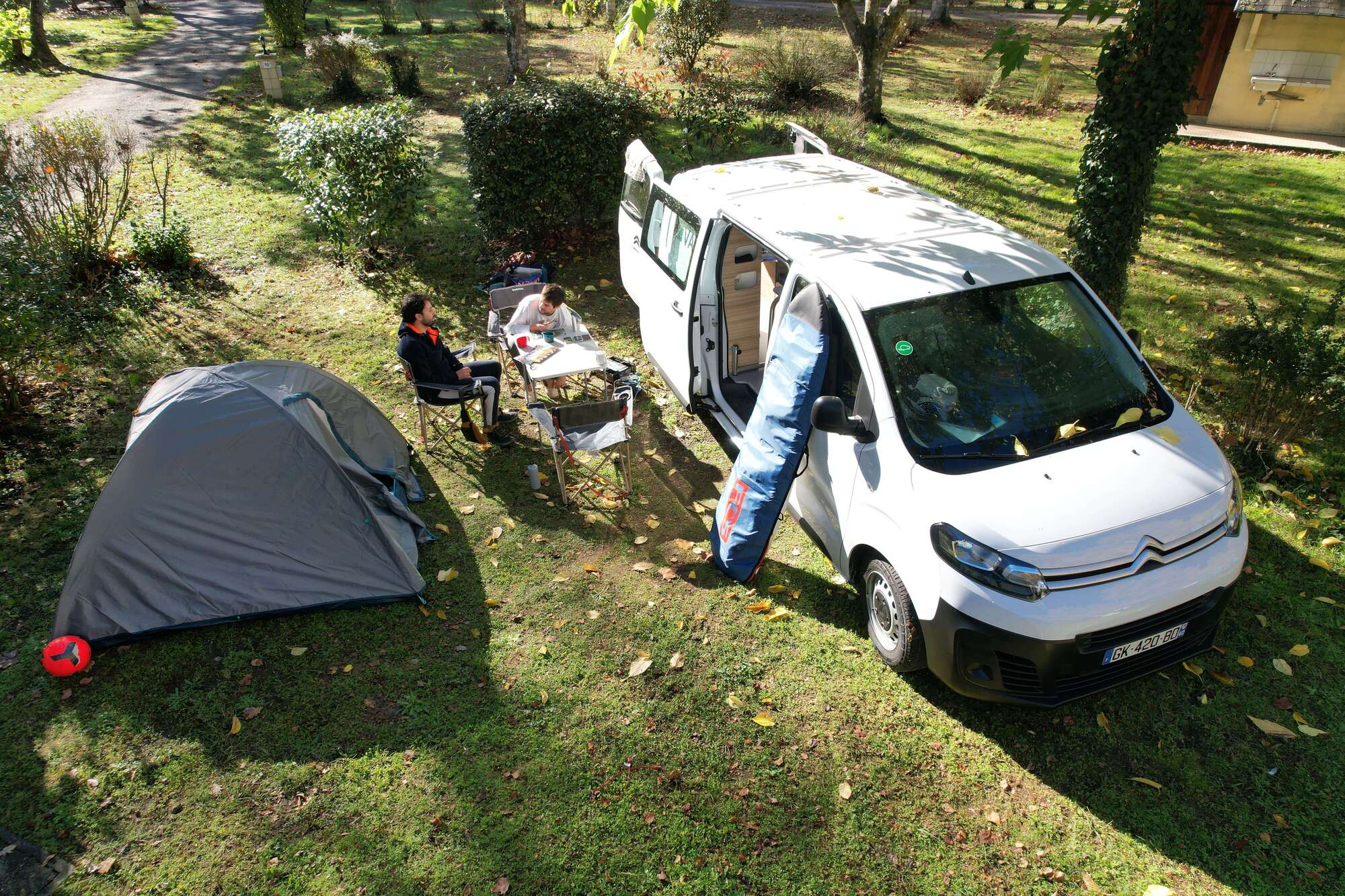 Van aménagé électrique en train de charger au camping